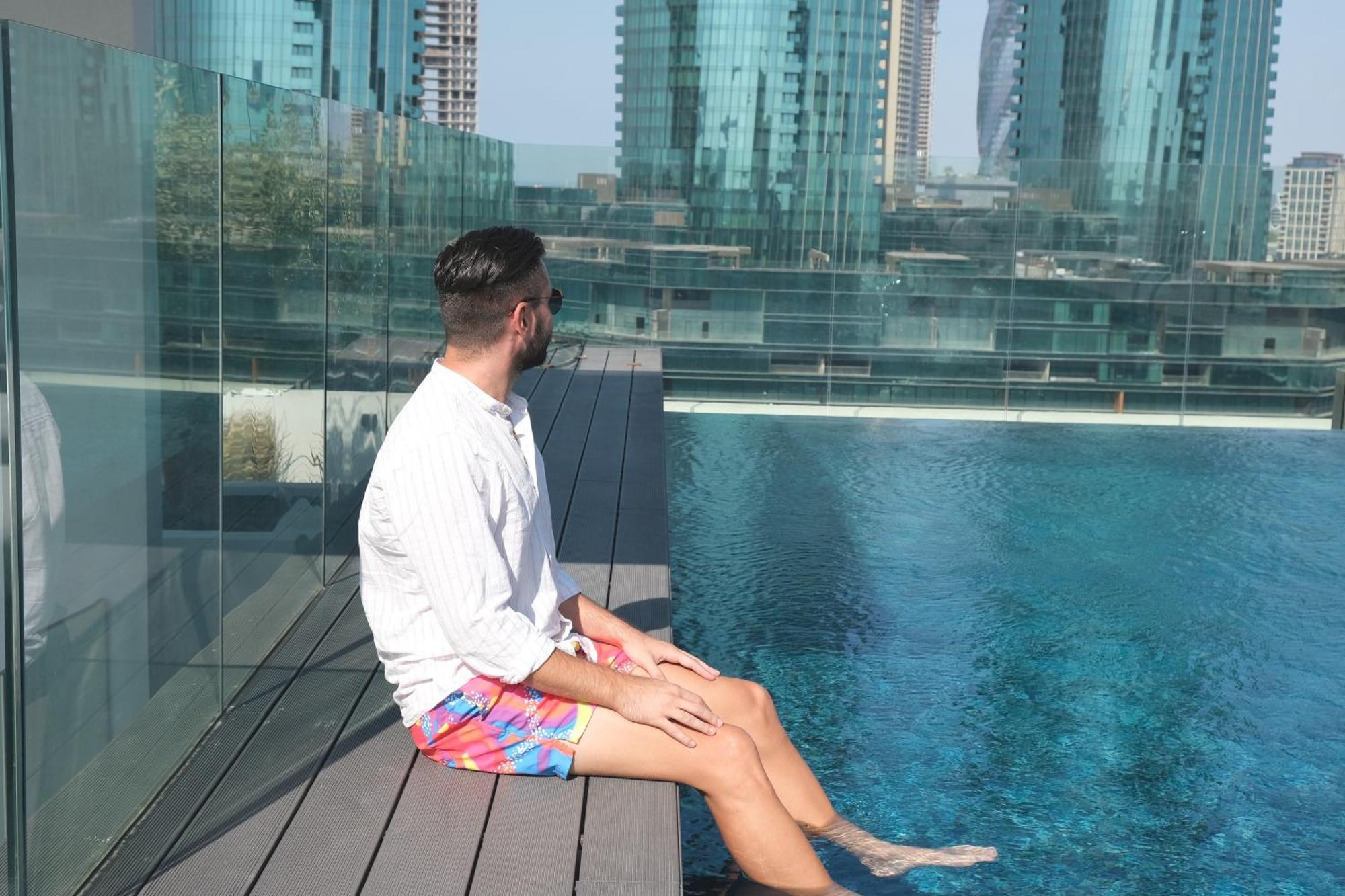 Charthouse Bahrain Manama Exterior foto A man sitting on the edge of a pool